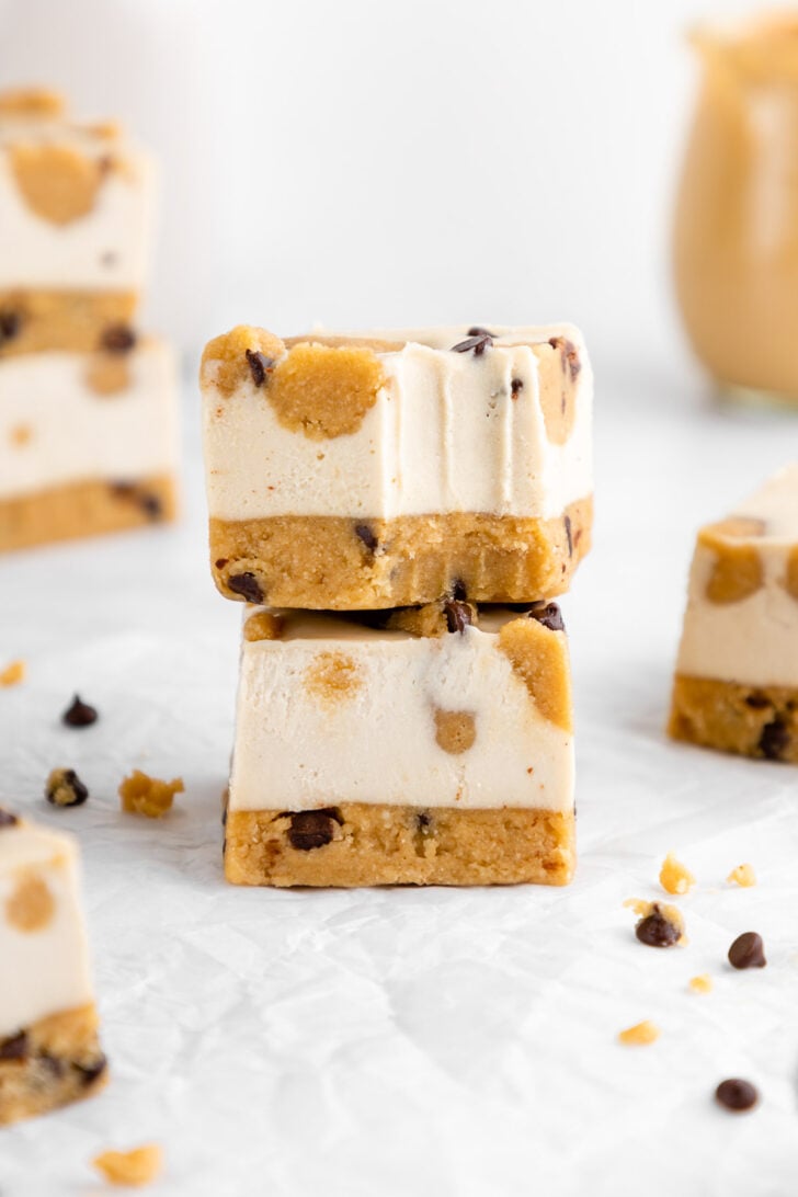 a stack of two no-bake cookie dough cheesecake bars with a bite taken out of one