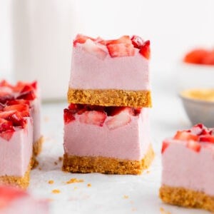 a stack of two no-bake strawberry cheesecake bars with graham cracker crust