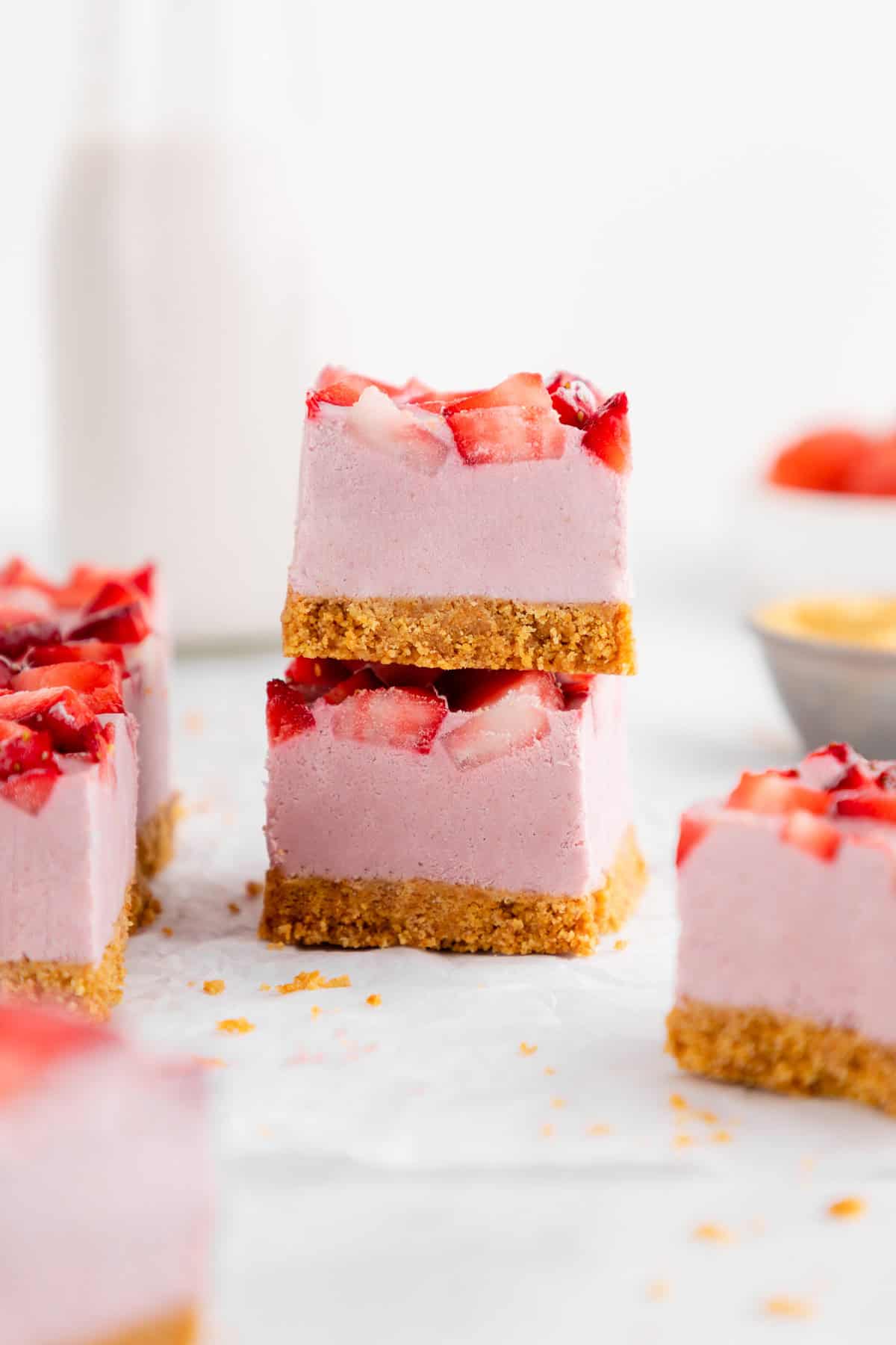 a stack of two no-bake strawberry cheesecake bars with graham cracker crust