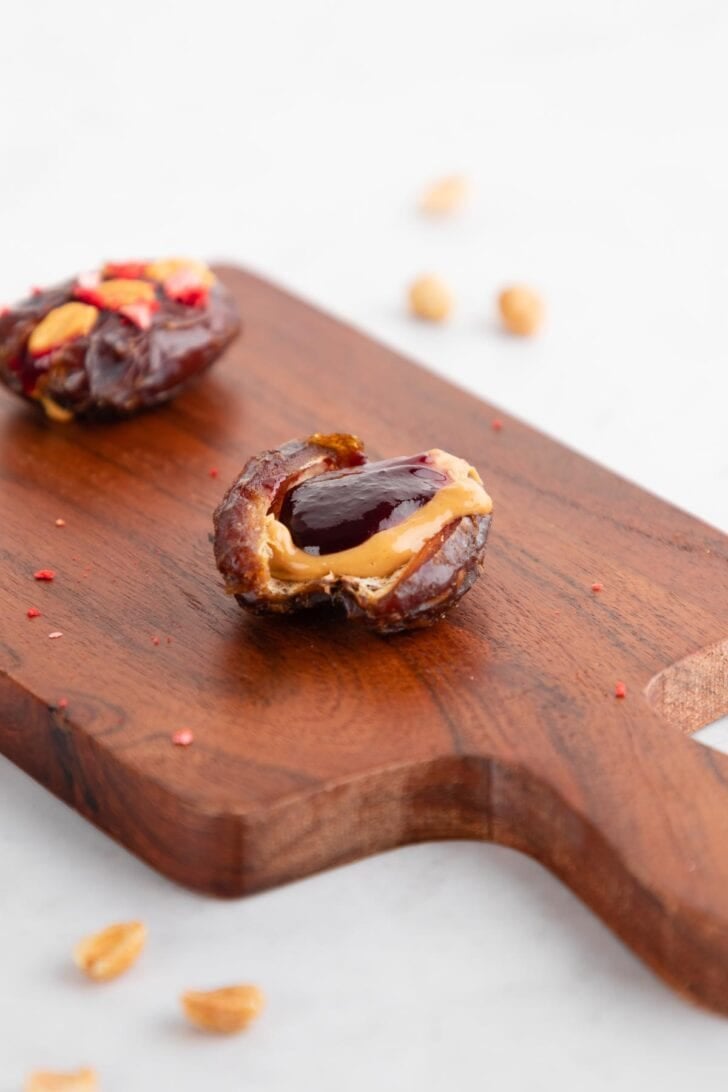 a medjool date sliced in half and stuffed with peanut butter and jelly