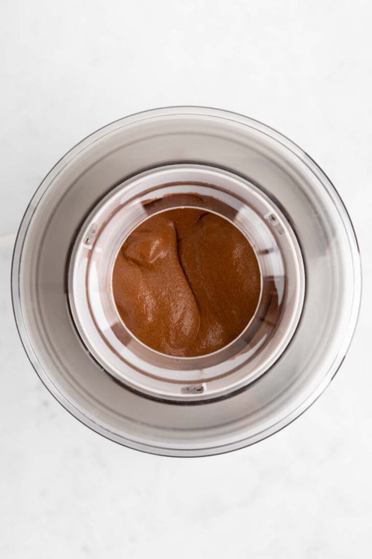 churning vegan chocolate fudge brownie ice cream inside an ice cream maker
