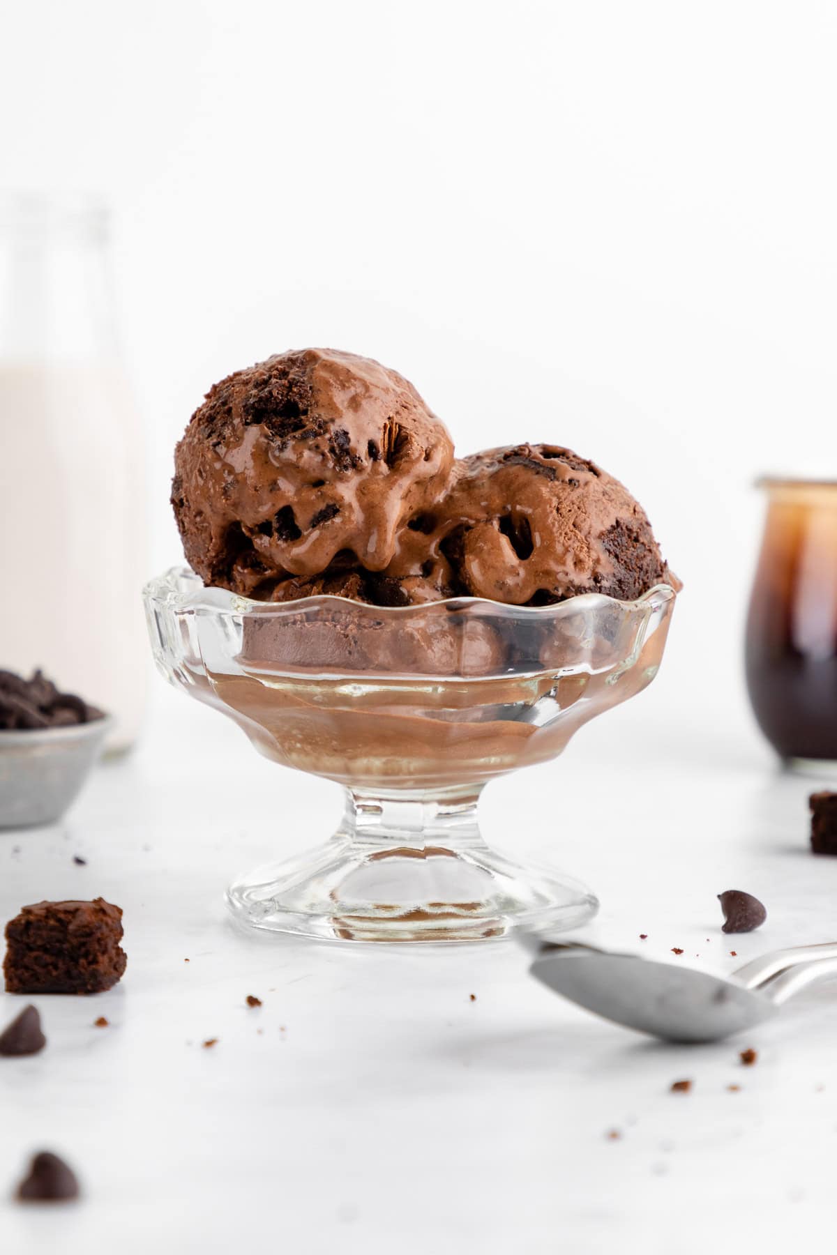 scoops of vegan chocolate fudge brownie ice cream inside a sundae glass