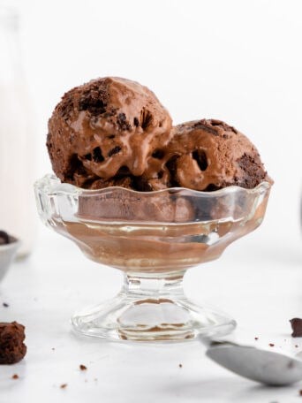 scoops of vegan chocolate fudge brownie ice cream inside a sundae glass