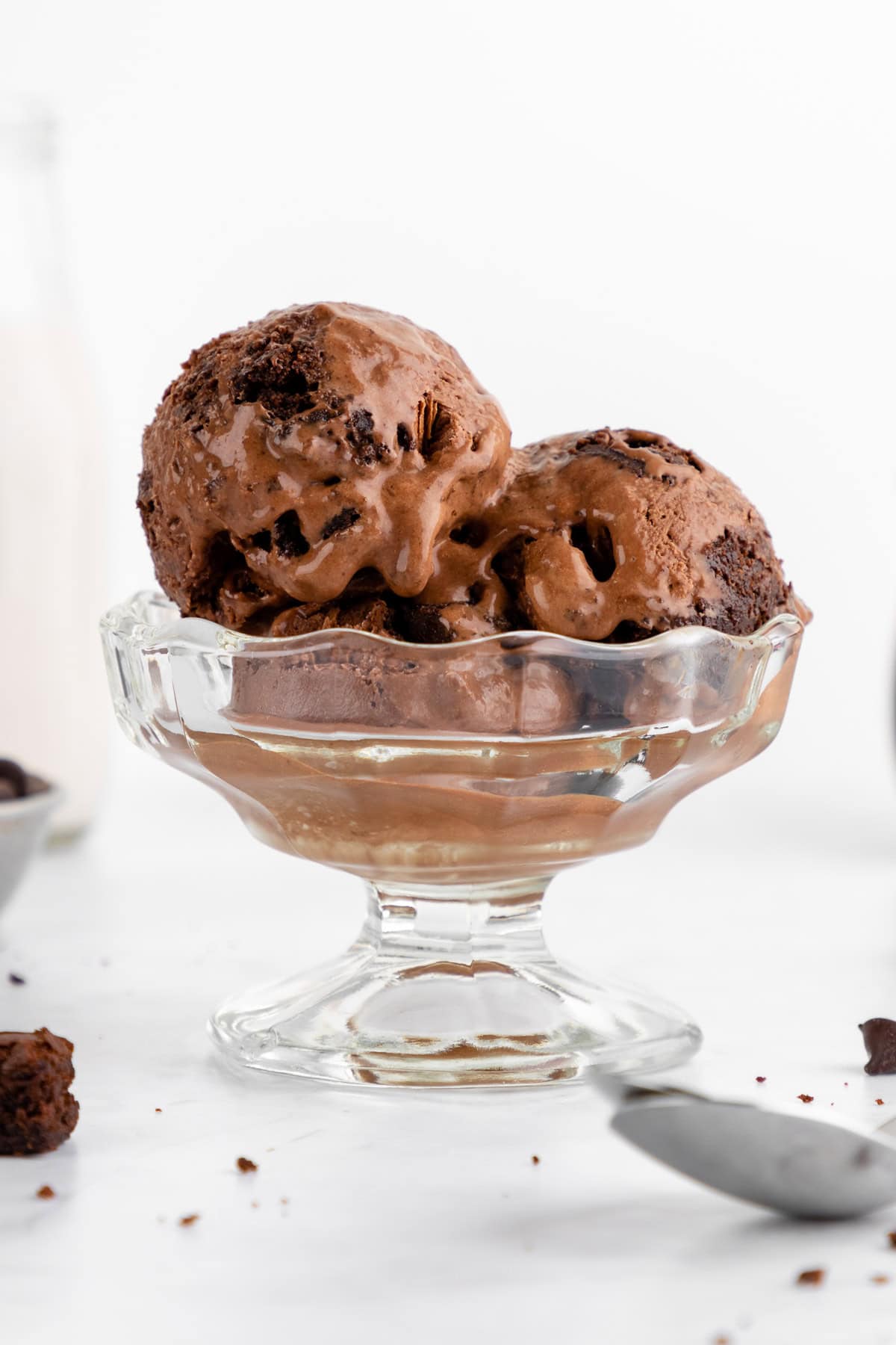 scoops of vegan chocolate fudge brownie ice cream inside a sundae glass