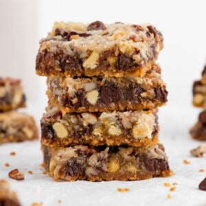 a stack of vegan seven layer magic cookie bars with sweetened condensed coconut milk