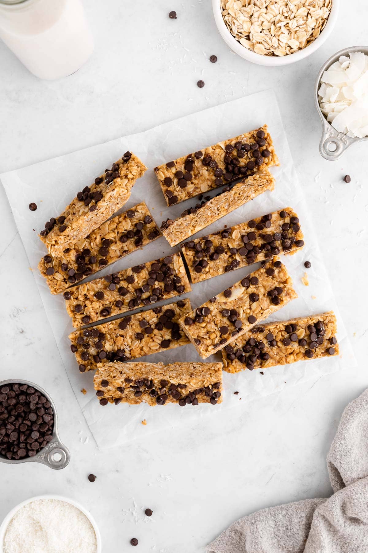 a pile of homemade coconut chocolate chip granola bars with shredded coconut and coconut flakes